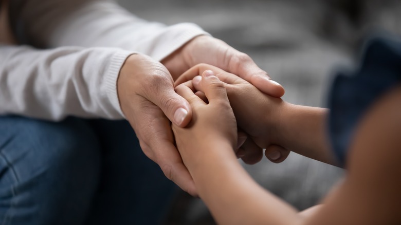 Holding child's hands