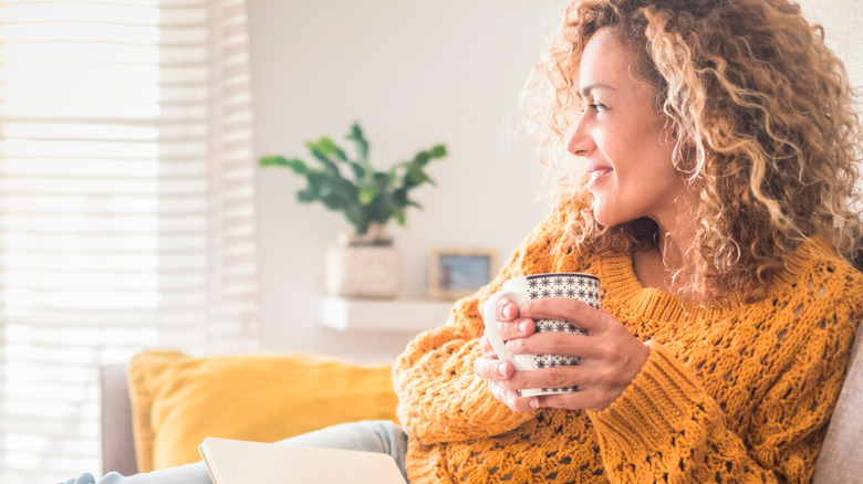 young woman reading with tea