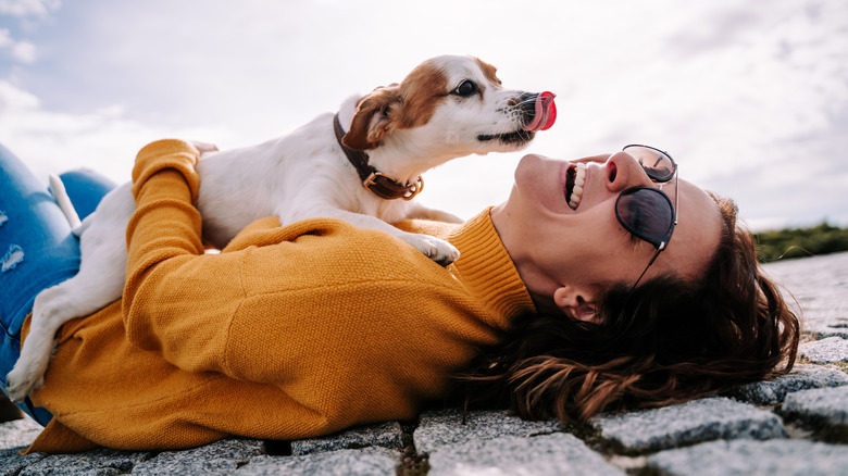 woman laughing with small dog