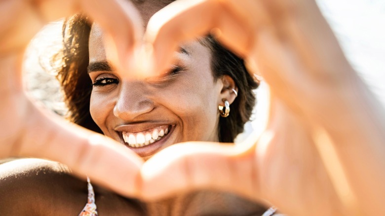 woman smiling with hand heart