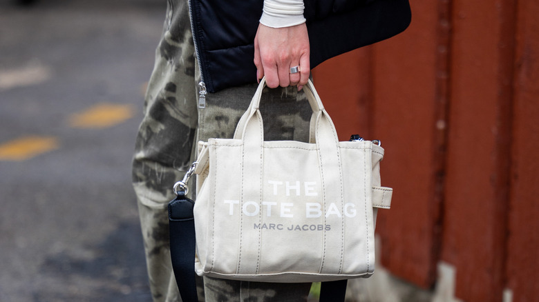 Person carrying a Marc Jacobs tote bag.