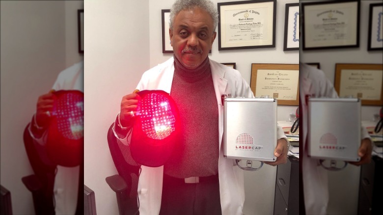 man holding laser hair cap