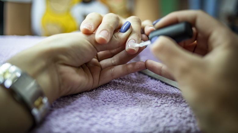 person painting nails with hardener