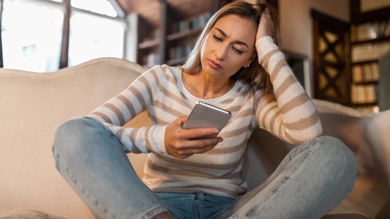 frustrated woman looking at phone