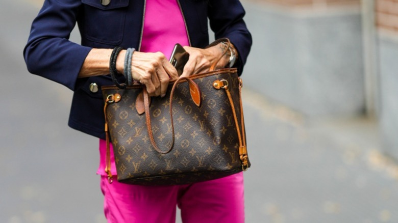 Woman reaching into Neverfull tote