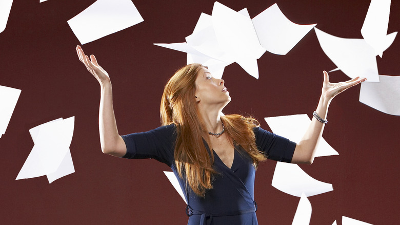 woman tossing papers in air