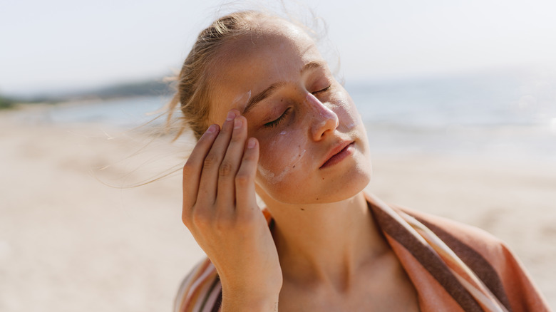 woman applying sunscreen at beach