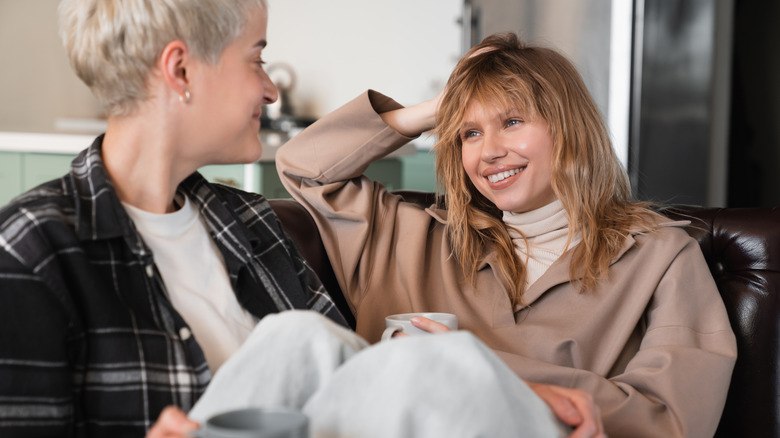 two women smiling on sofa