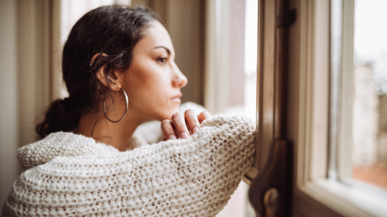 Woman looking pensively out window