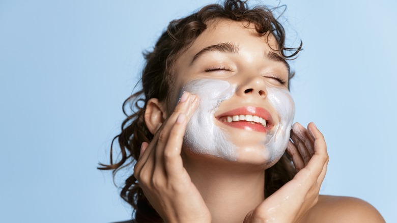 Woman applying mud mask 