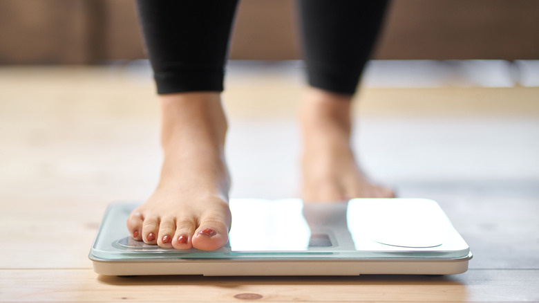 woman standing on weight scale