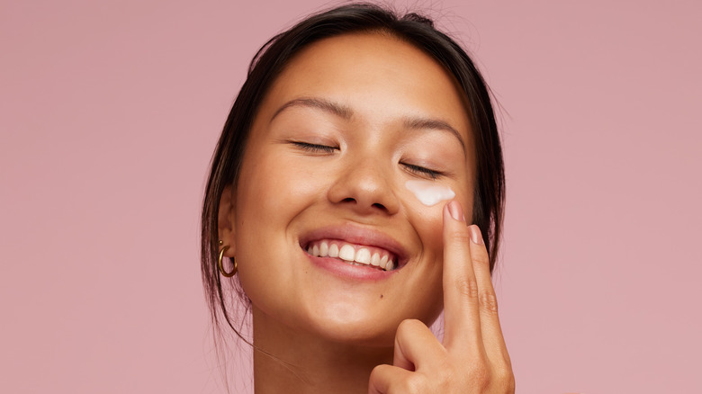 woman applying face moisturizer