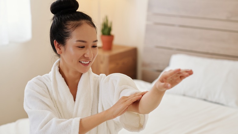 Woman applying a moisturizer.