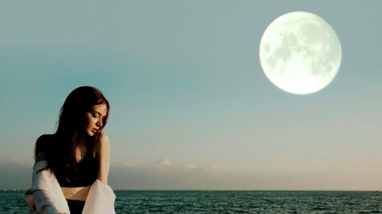 Girl sitting by full moon