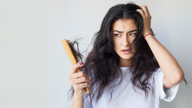 woman brushing damaged hair