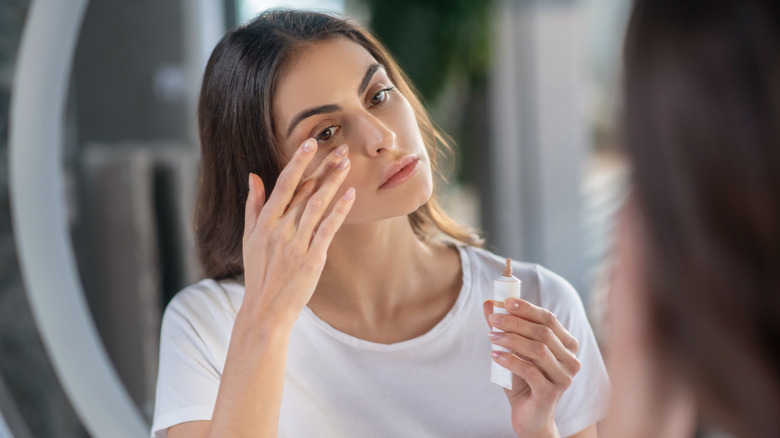 woman applying face concealer