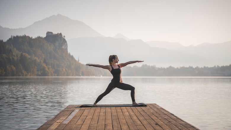 Person practicing yoga by the river