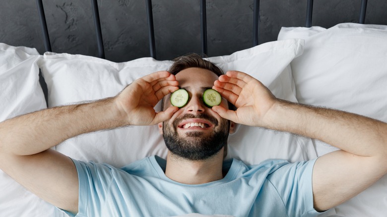 Man with cucumbers on eyes 