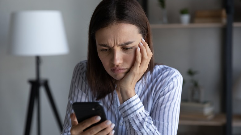 woman annoyed looking at phone