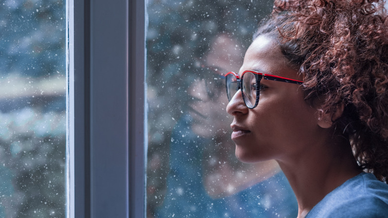 Woman looking out window with reflection