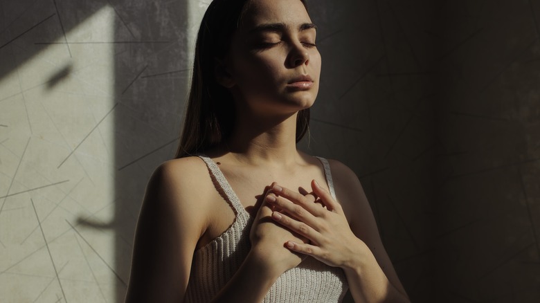 Woman meditating in dark room