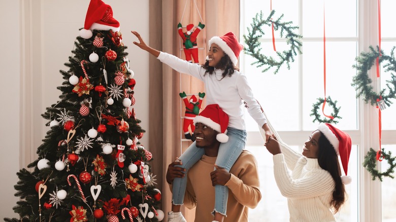 Black family by Christmas tree