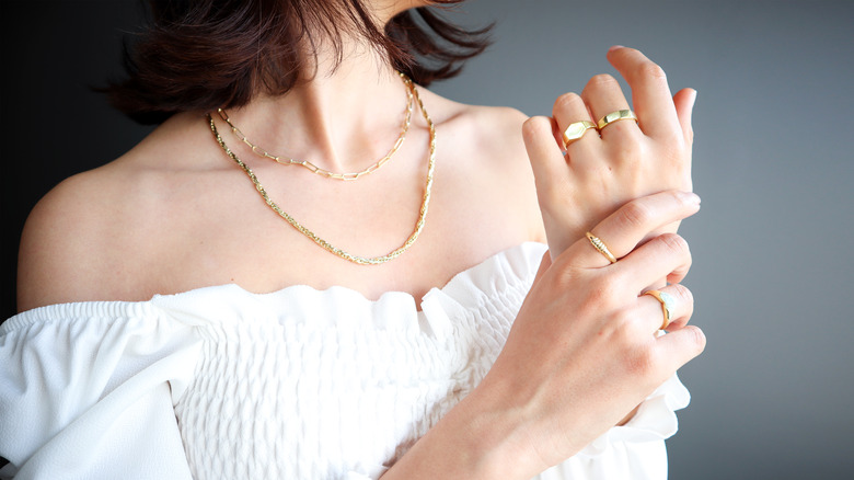 woman putting on jewelry 