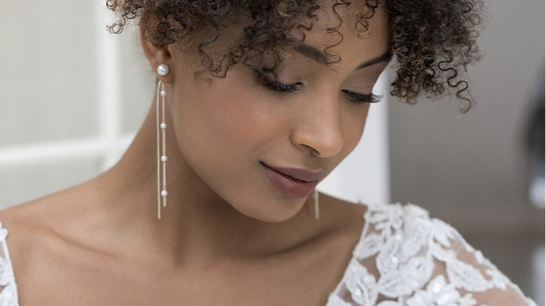 Bride wearing pearl earrings, lace