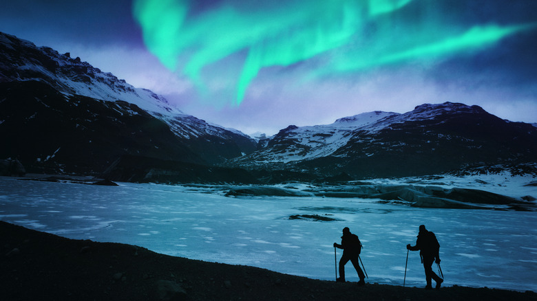 Hikers under Icelandic Northern Lights