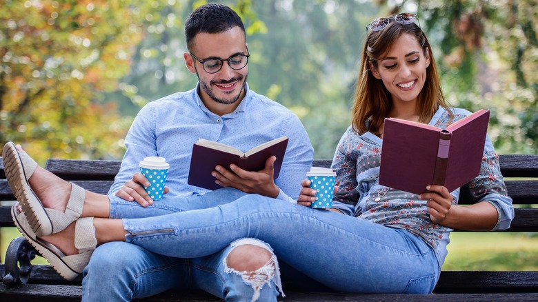 young couple reading in park