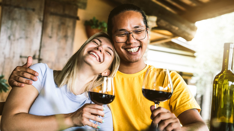 couple laughing and drinking wine