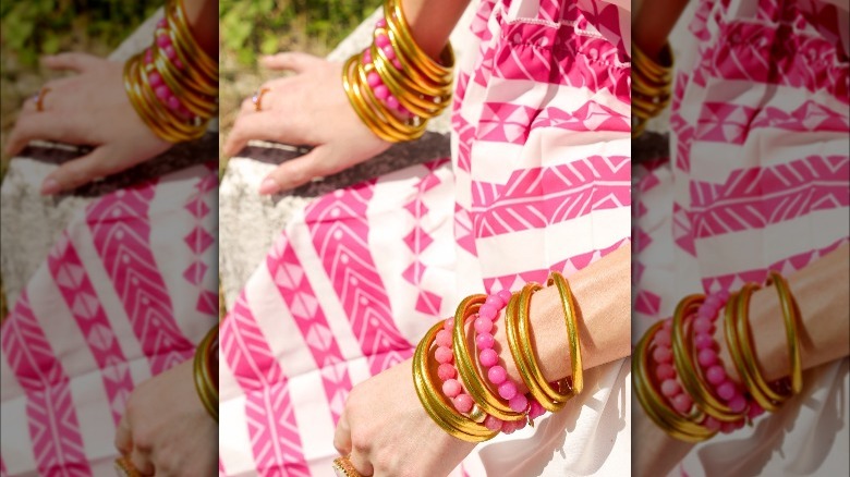 Gold bangles and pink beaded bracelets 