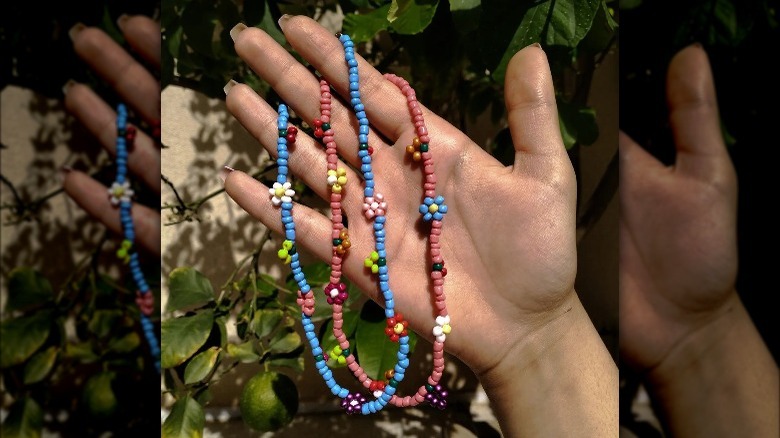 Hand holding retro flower beaded necklaces