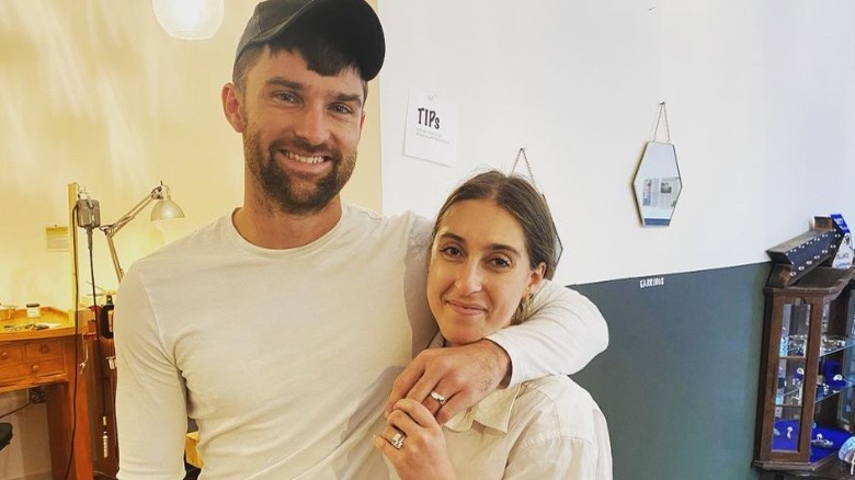 Couple poses wearing white gold wedding rings