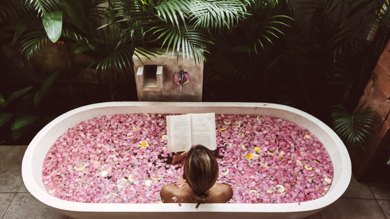 Woman in floral bath, reading