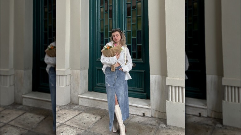 Woman wearing denim maxi skirt and white boots