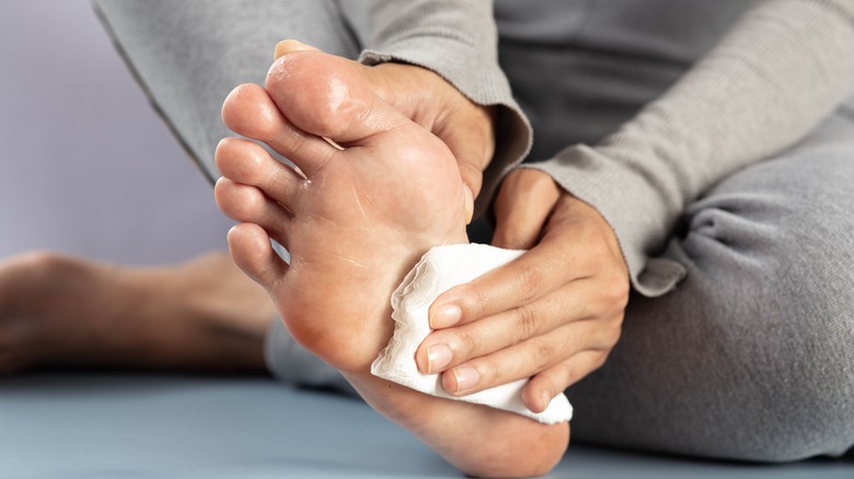 woman wiping sweaty feet