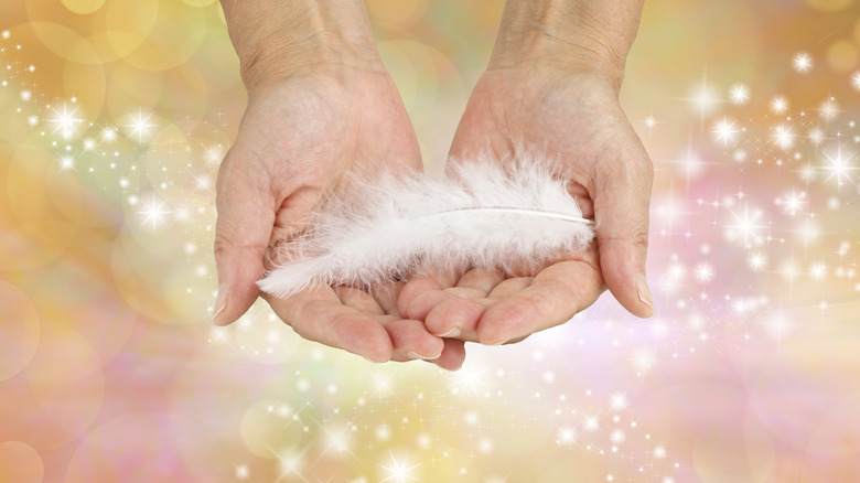 hand holding white feather