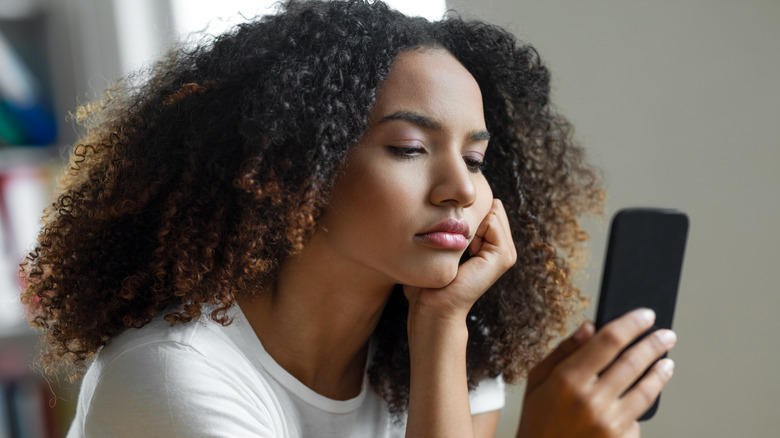 sad woman with smartphone