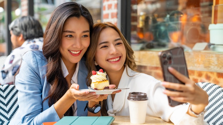 women taking photo with dessert