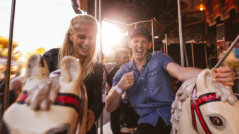 Laughing couple riding merry-go-round