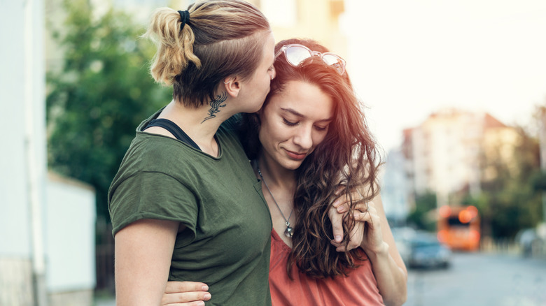 women embracing on street