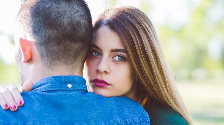 unhappy woman hugging man