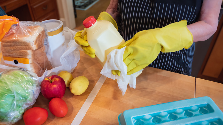 woman using gloves unpacking groceries