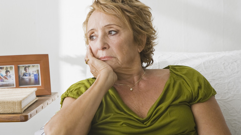 Woman sitting on couch upset