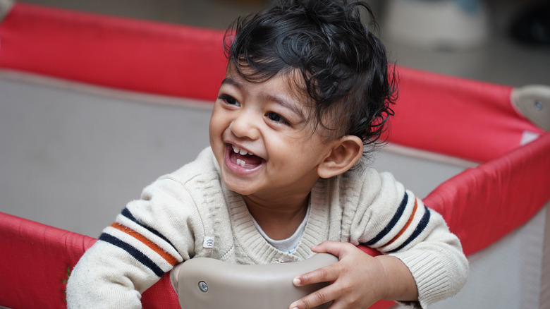 Baby smiling in playpen