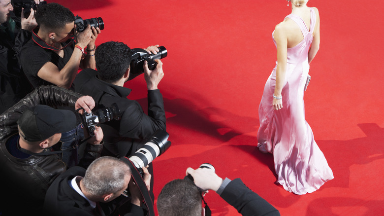 Photographers snapping woman on red carpet