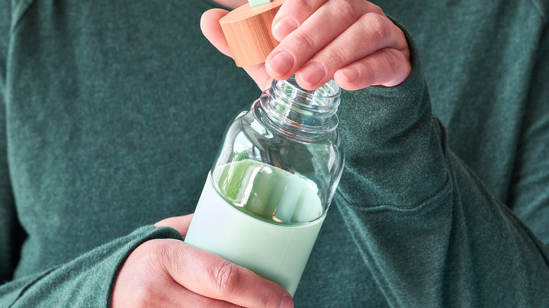 person uncapping water bottle