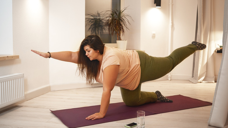 Woman completing a bird dog yoga position