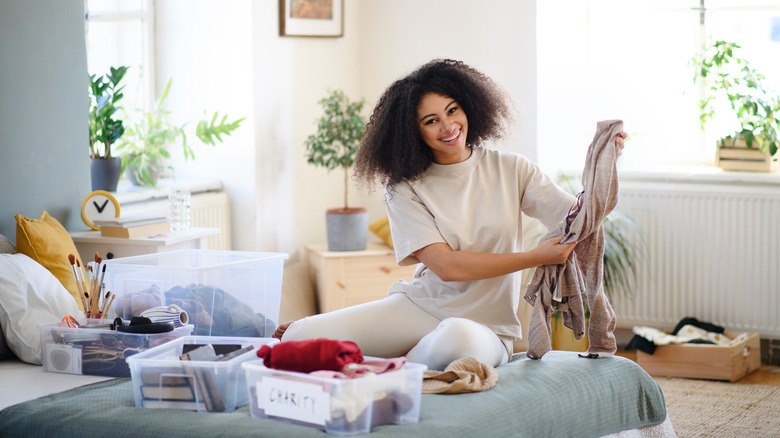 Woman decluttering home sorting clothing